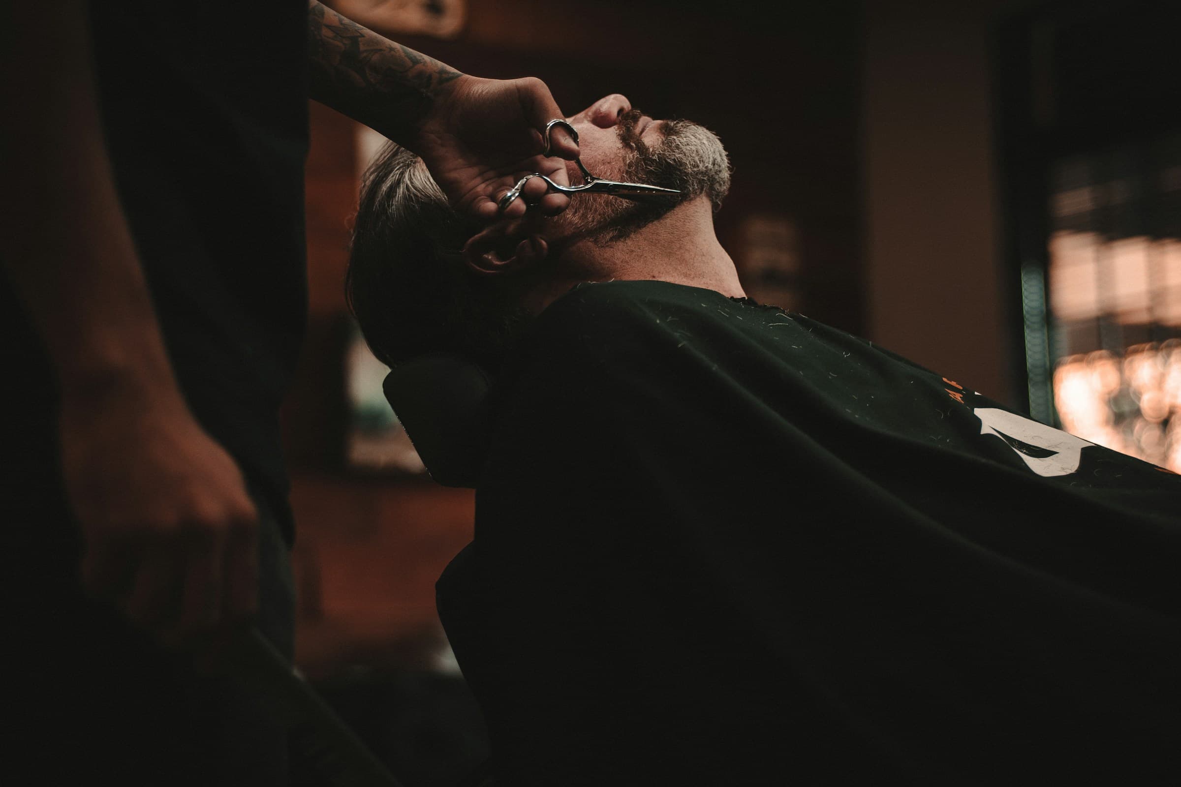 picture of a man getting his beard trimmed by a barber
